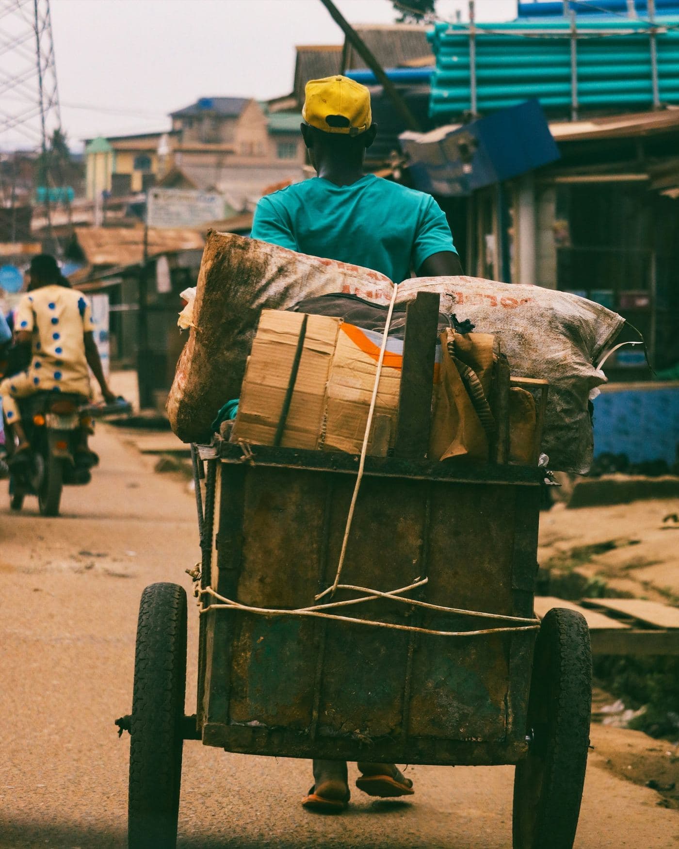 A worker transports goods through a busy street